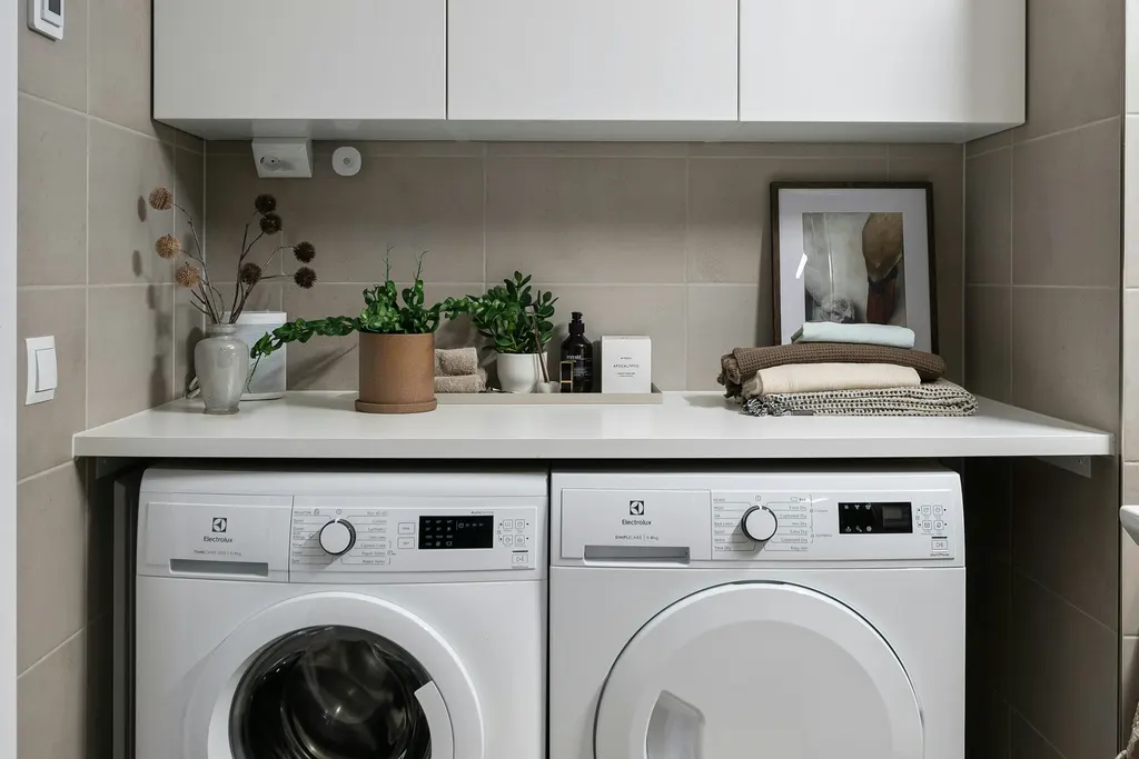 A laundry room with a washing machine and a tumble dryer