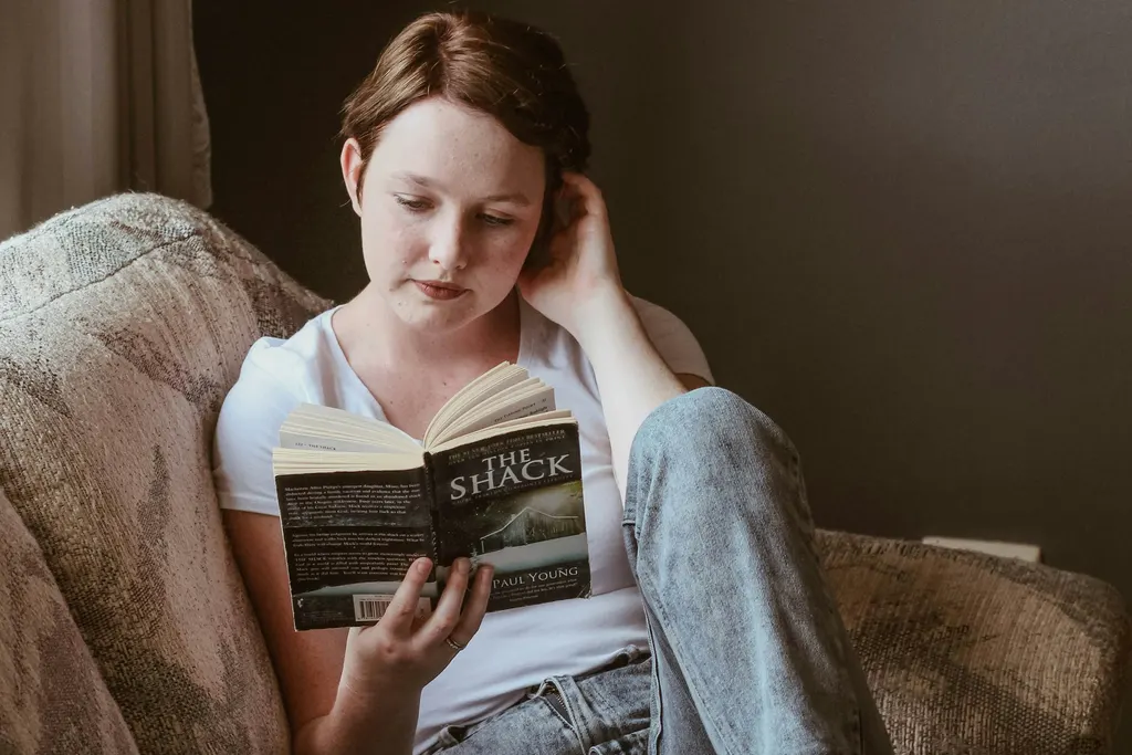 A woman sitting on a sofa reading